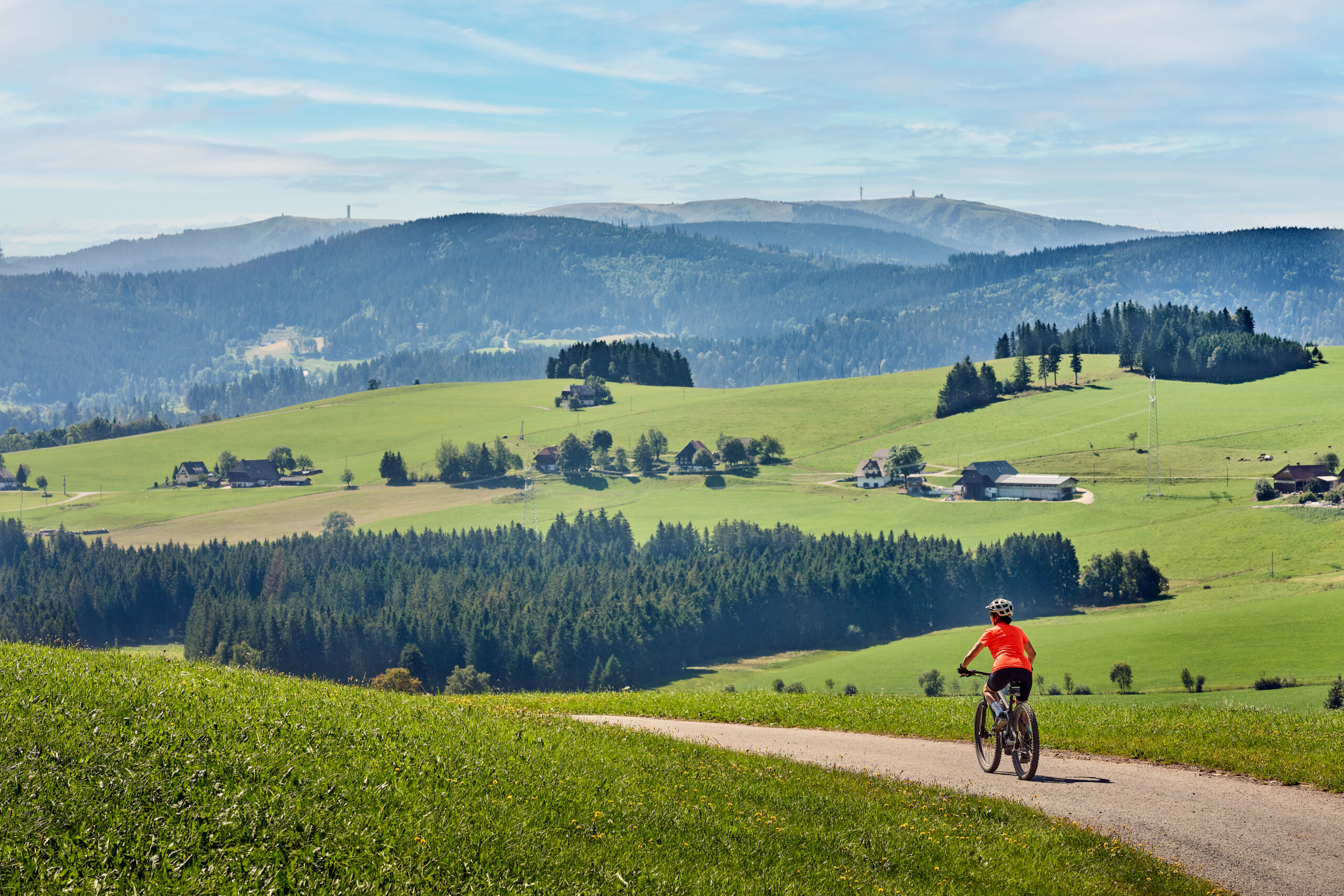 Frau auf ihrem Elektro-Mountainbike im Schwarzwald unterhalb des Feldberggipfels in Baden-Württemberg, Deutschland.