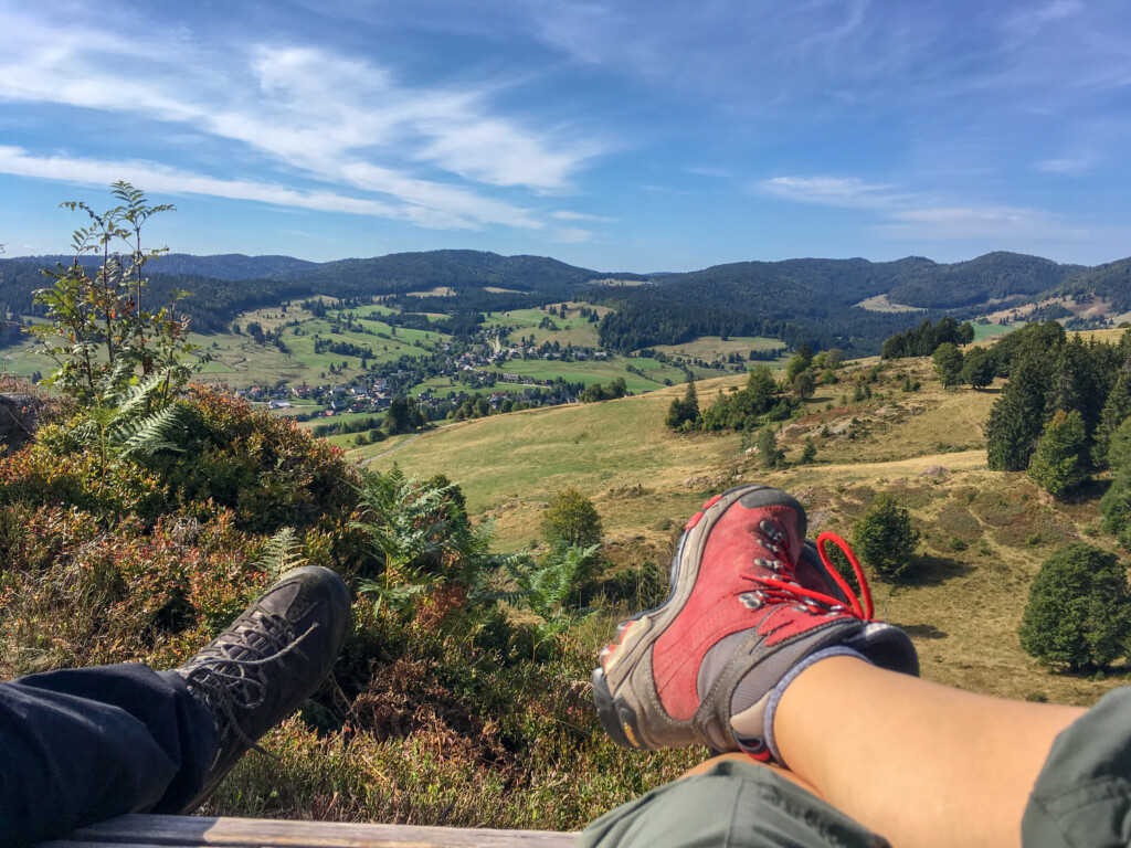 Foto von den Schuhe von zwei Wanderern, die Pause auf einem Hügel machen.